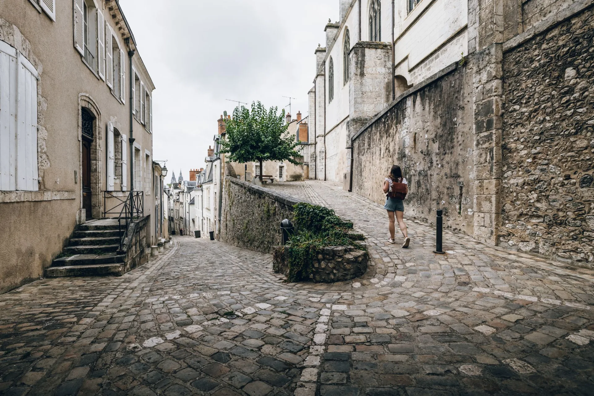 Jeune femme se promenant dans des ruelles pavées de la ville