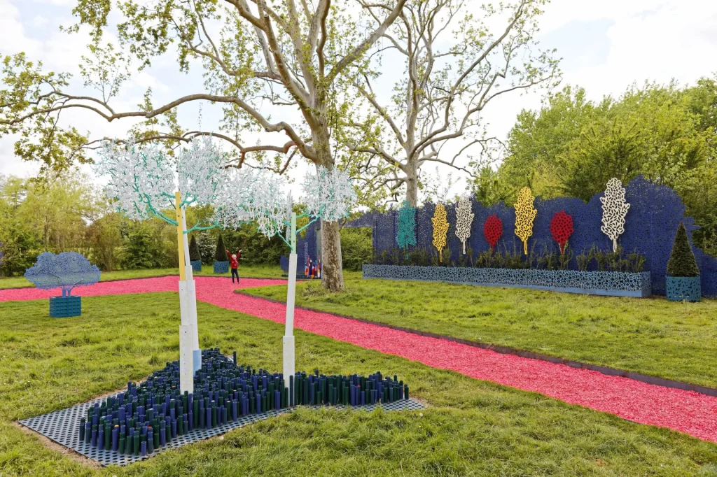 Allées de couleur rose qui coupent à travers un parc, des sculptures d'arbres de couleur sont fixés en bordure