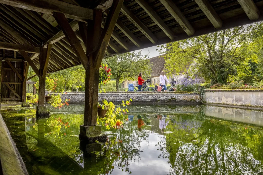 Cyclotouristes près d'un lavoir