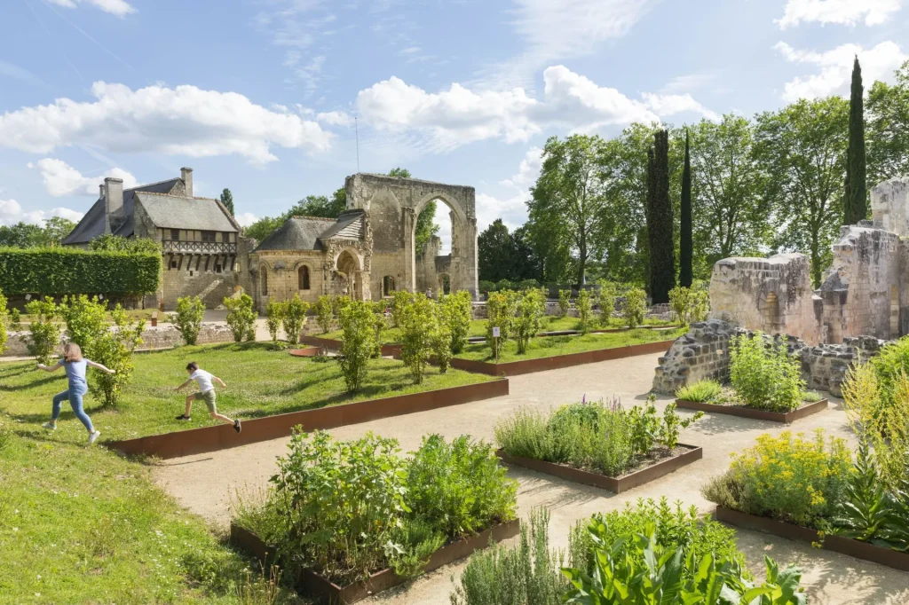 Enfants qui courent parmi les carrés du jardin devant les vestiges