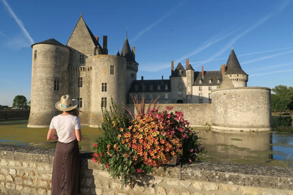 Femme devant les douves et le chateau de Sully-sur-Loire