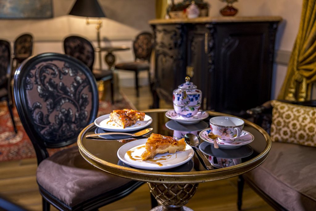 Salon de thé de la Maison Tatin. Tasses, théière et assiettes avec des parts de tarte Tatin sur une table.