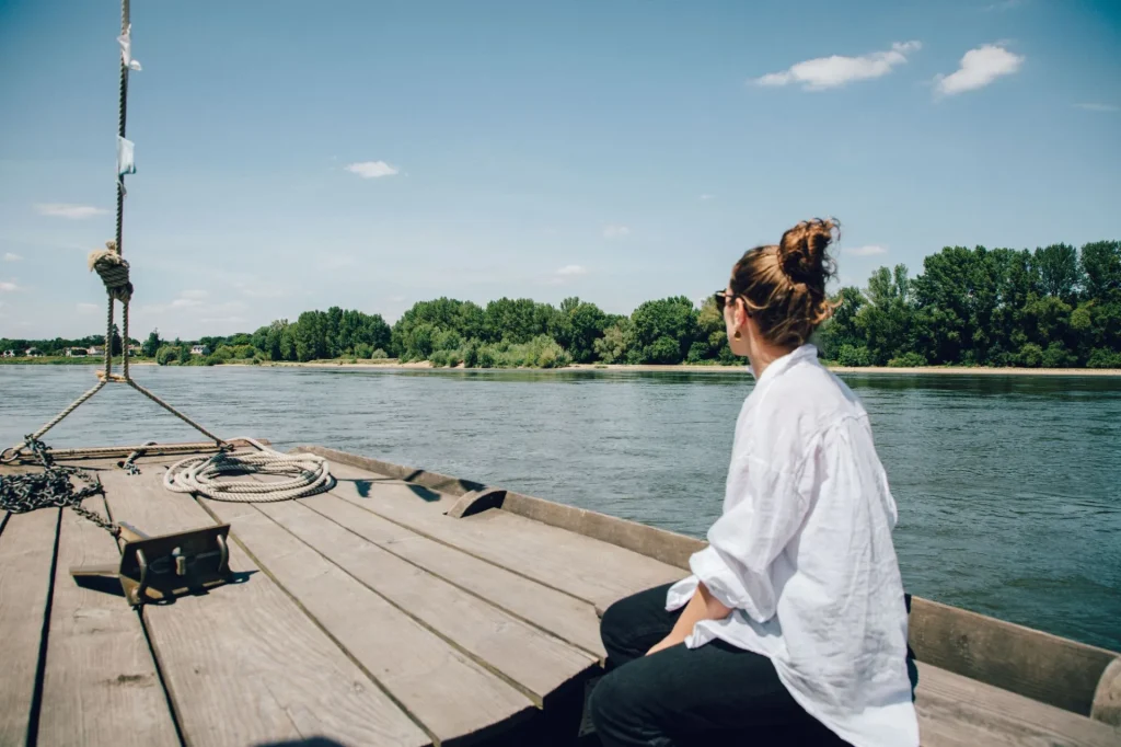 Femme sur le pont d'un bateau qui navigue sur la Loire