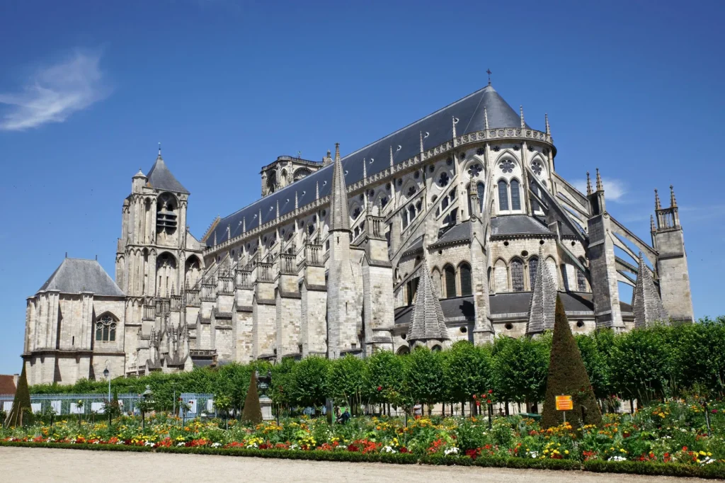 Cathédrale de Bourges avec les arbres et parterres de fleurs au 1er plan