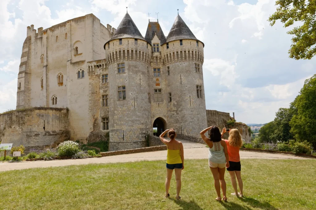 3 femmes de dos en train de regarder le château de Nogent-le-Rotrou et de le photographier