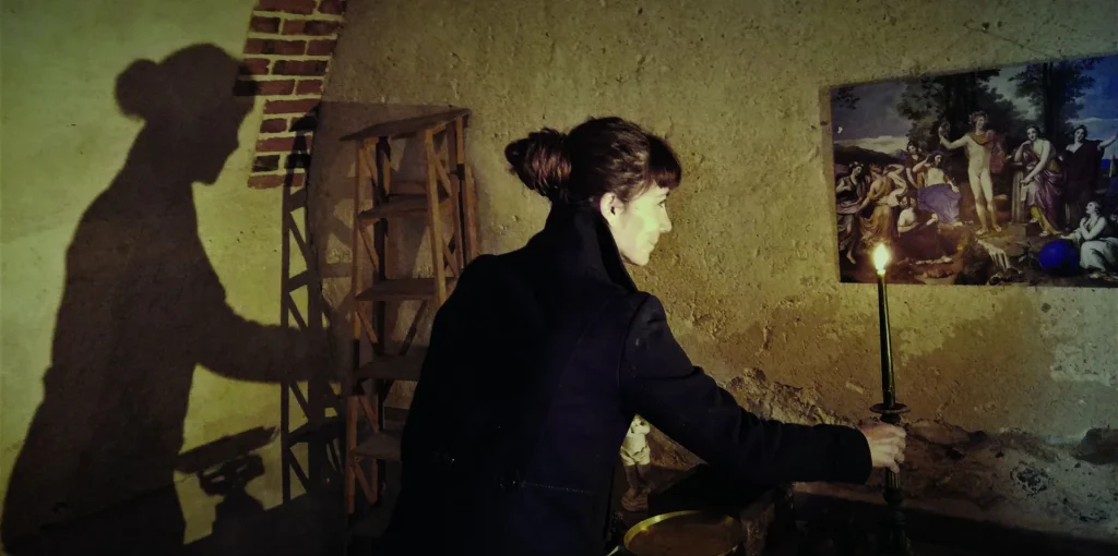 Une femme tenant une bougie dans l'Escape Game du château de La Bussière