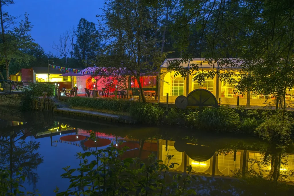 Barnums de la guinguette de Trôo allumés et colorés, au bord de l'eau