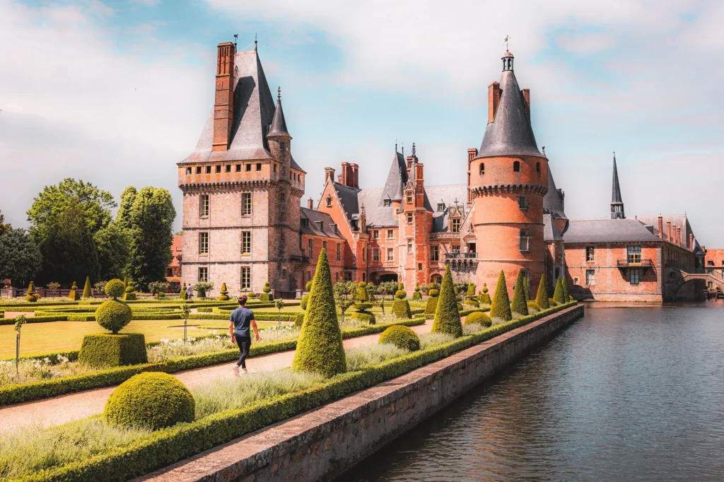 Vue sur le château de Maintenon avec un homme marchant dans l'allée