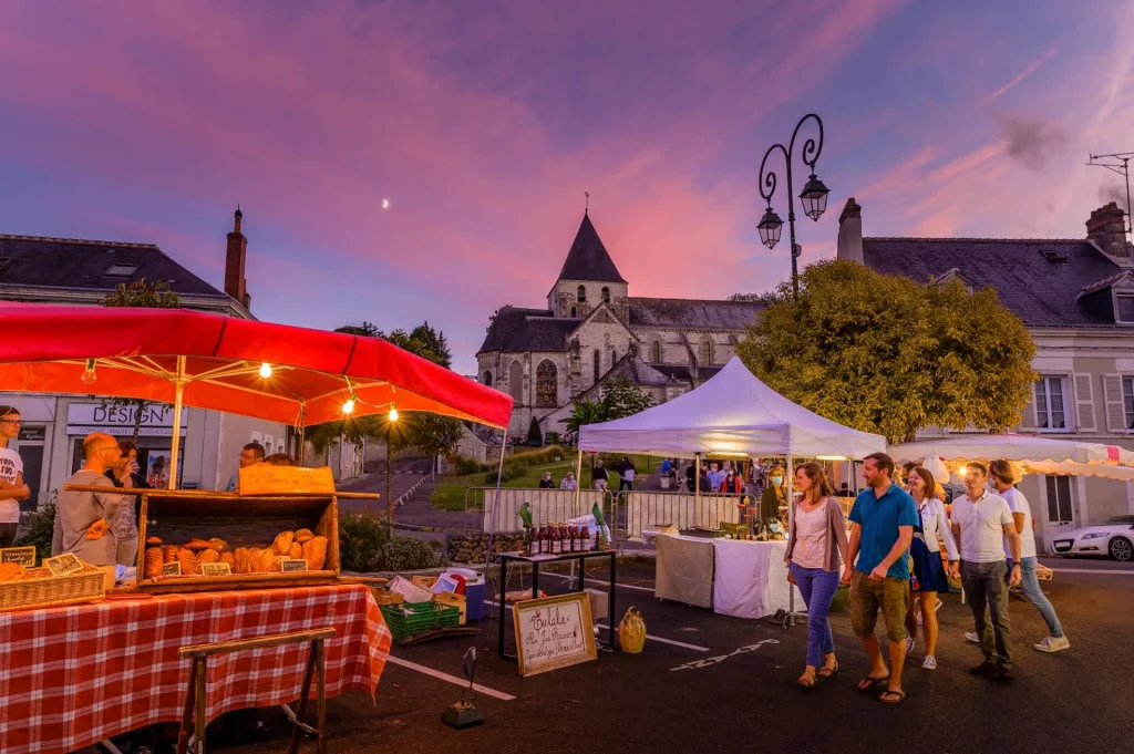 Couples qui passent devant les stands du marché d'Amboise en nocturne