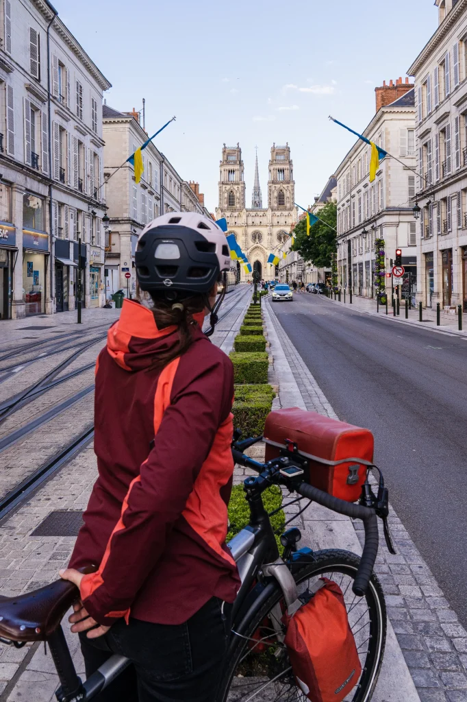 Cyclotouriste de dos regardant la cathédrale d'Orléans