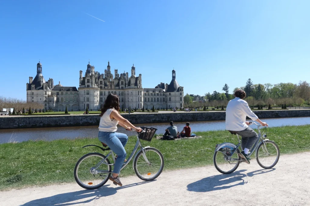 Couple à vélo devant le château de Chambord