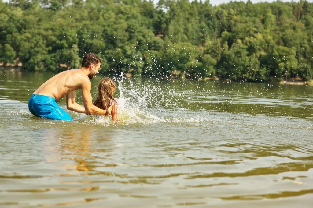 Un homme et sa fille se baignant dans un plan d'eau