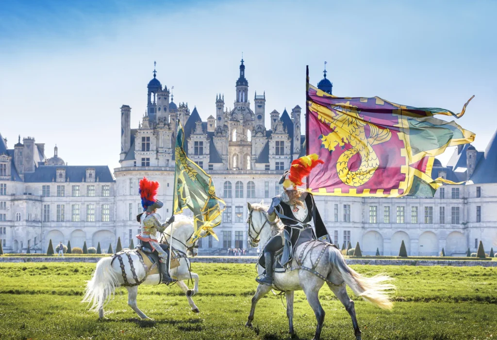 Spectacle équestre du château de Chambord : cavaliers portant des drapeaux devant le château
