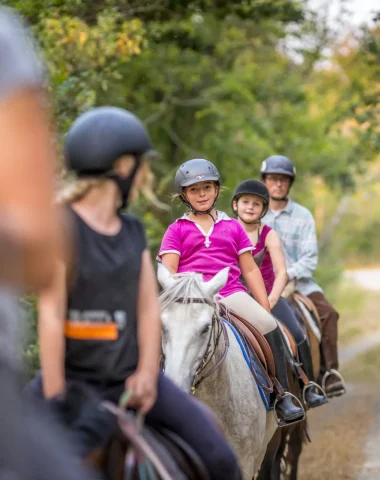Groupe enfants et adultes à cheval en balade en forêt