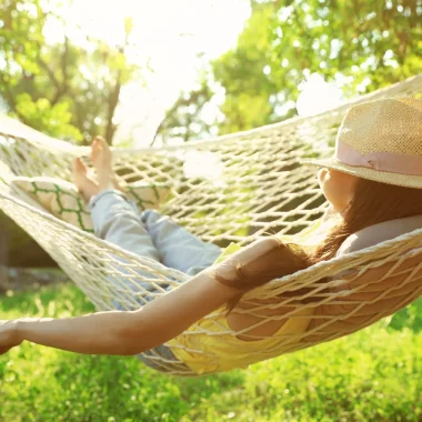 Femme avec un chapeau allongée dans un hamac