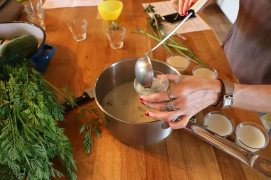 Une dame rempli des ramequins lors d'un atelier culinaire à la Grange aux Savoir-faire