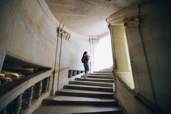 Femme qui monte les escaliers du château de Chambord