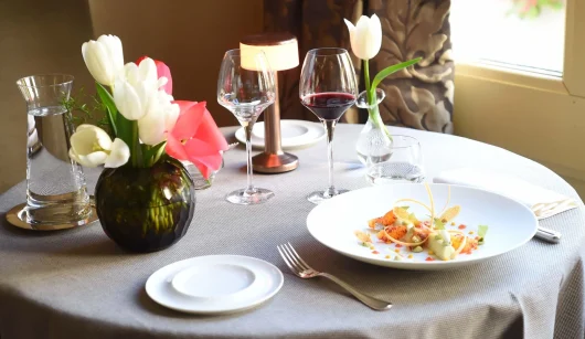 Table dressée avec une assiette contenant une orange sanguine au restaurant du château de Pray