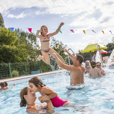 Dans la piscine, un papa joue avec sa fille dans l'eau à la base de loisirs de Descartes