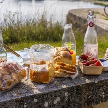 Biscuits, jus de fruits, fruits, fromage, rillettes sur un présentoir en bord de Loire