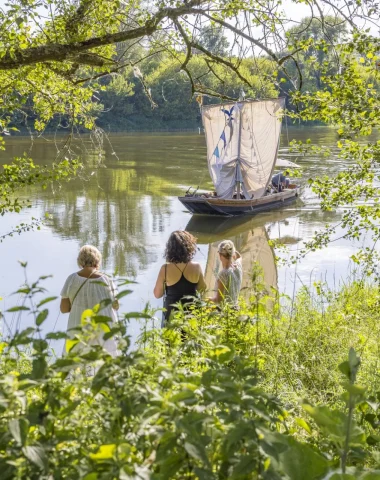 3 femmes sur les rives de la Loire regarde passer un bateau traditionnel de Loire