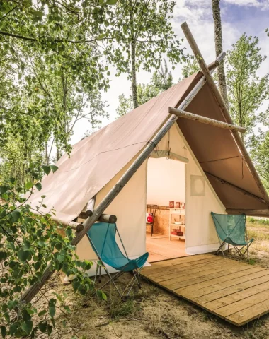 Toile de tente posée sur un sol en bois au milieu des arbres