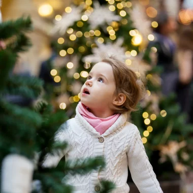 Petite fille devant un sapin de Noël